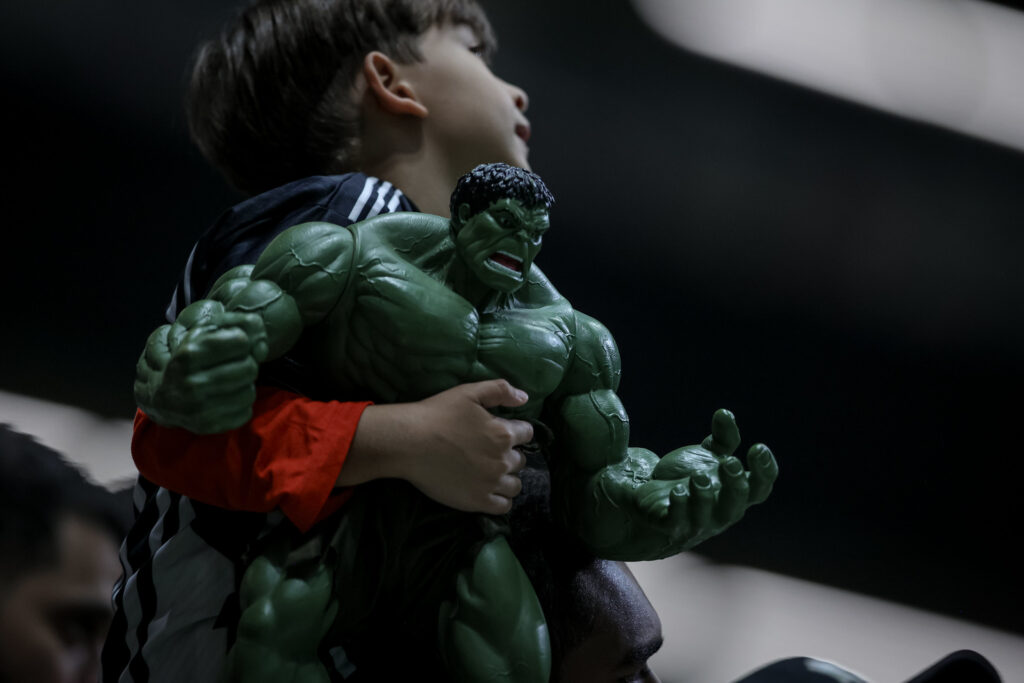 Um menino carregando o boneco do Hulk no braço em referência a Givanildo